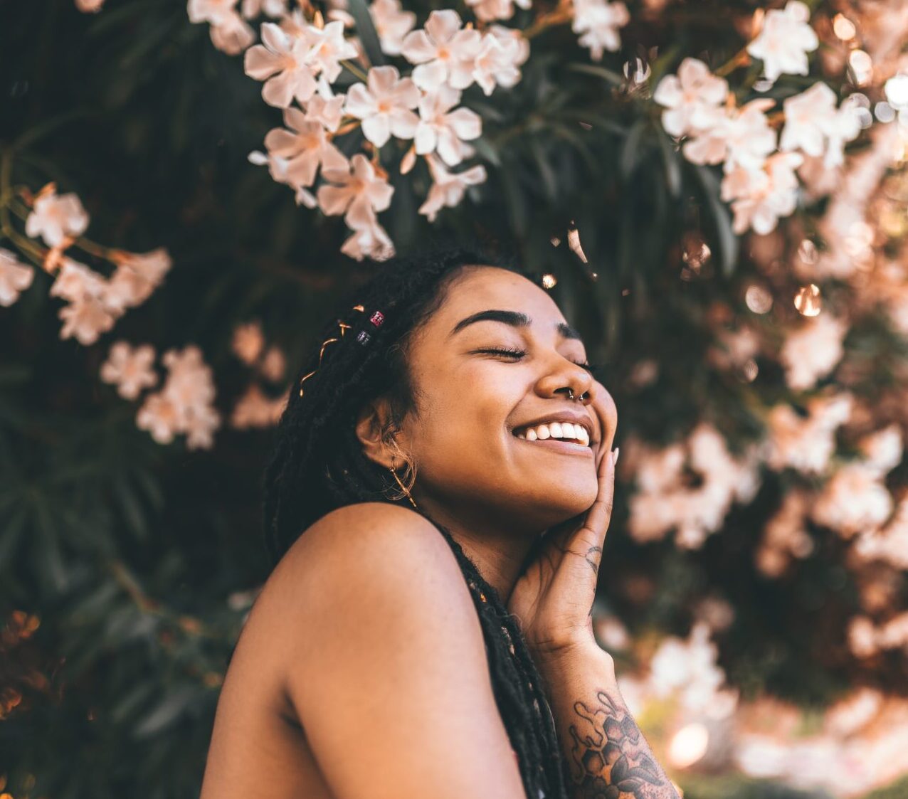woman smiling with blossom tree behind