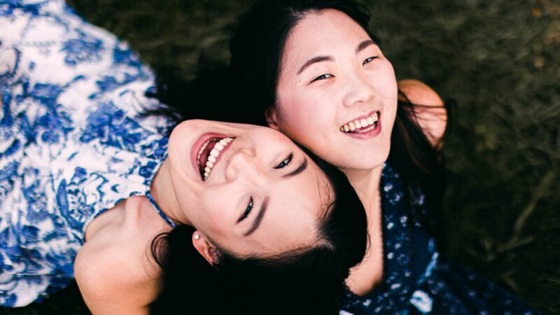 two young girls smiling and lying down